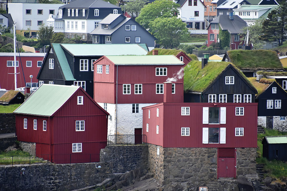 Colorful, geometrically tangent houses cascade up a hill