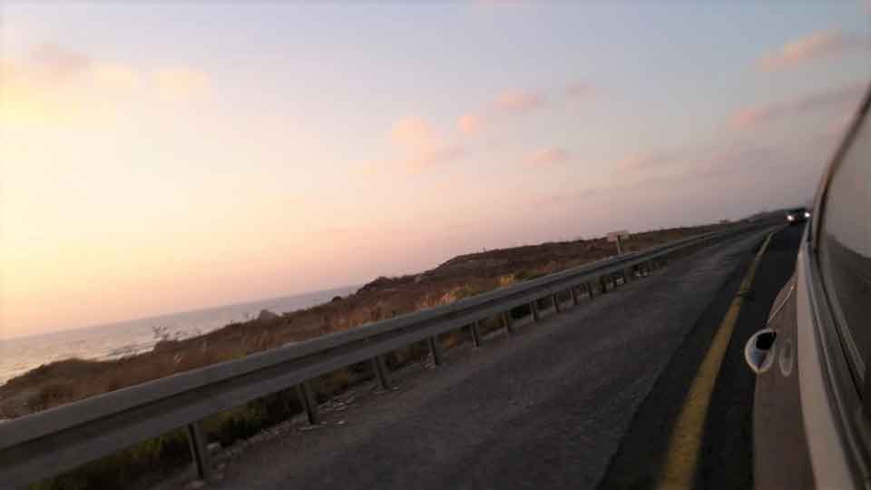 A photograph of a road as seen from a car window