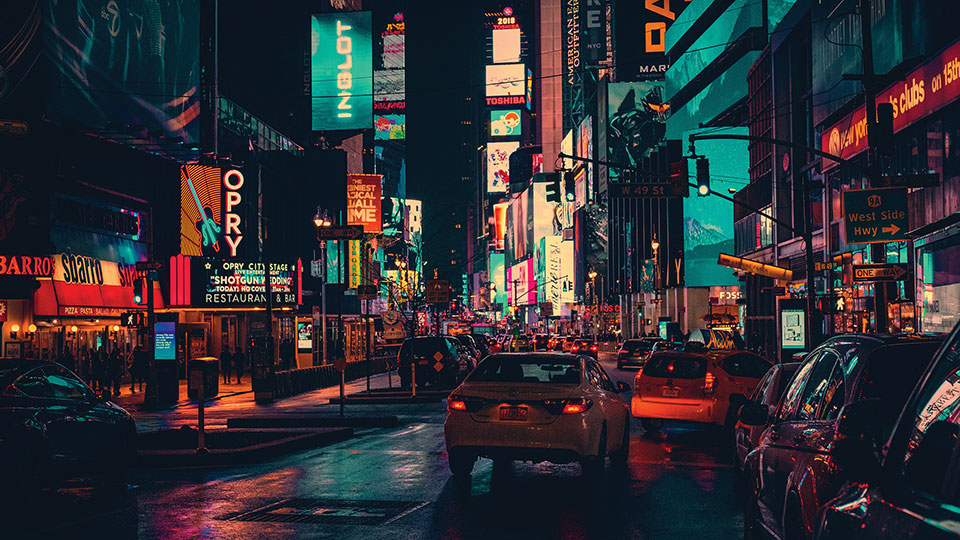 A dense urban scene with brightly colored signs lighting the night