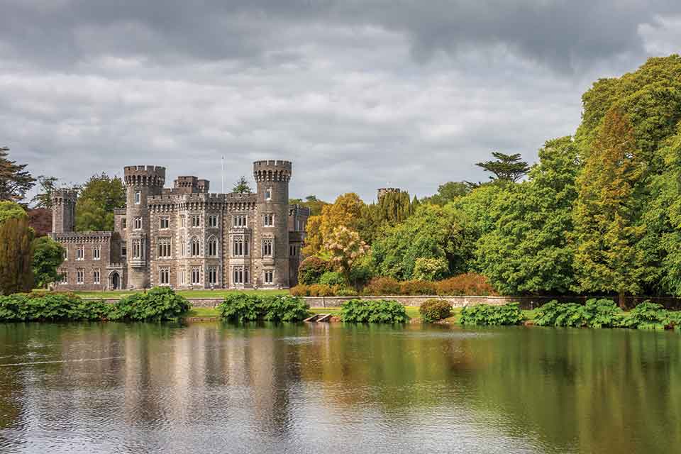 A castle swathed in forest sitting at water's edge