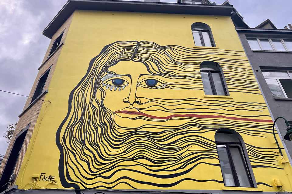 A photograph of a mural with a woman's face with flowing hair