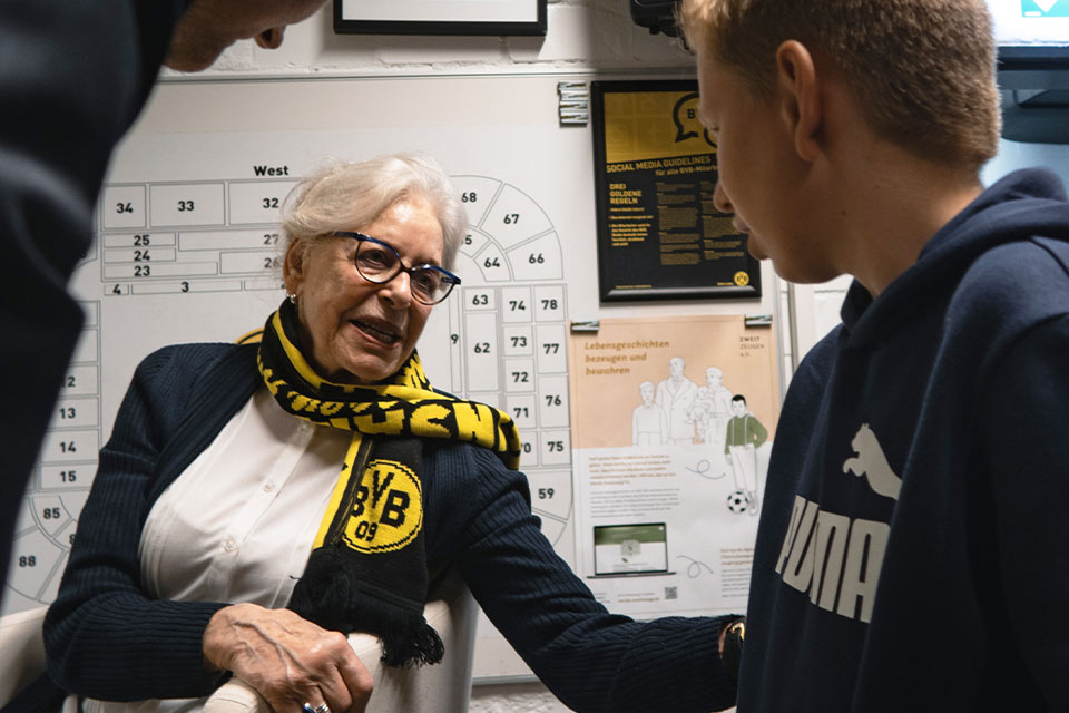 Photo of Holocaust survivor Eva Weyl speaking to a young participant at the BVB-Lernzentrum in Dortmund 