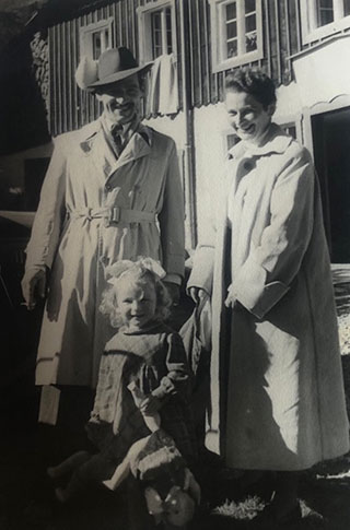 A black and white photograph of couple in travel dress with their child