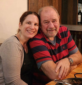 A photograph of a young woman posing with her father