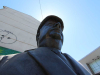 A photograph of a statue taken from down low with the sun's halo encircling the head