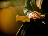 A close-up shot of a book resting in an unknown person's lap with light streaming in from the left