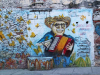 A photograph of a mural depicting a cartoonish drawing of Gabriel Garcia Marquez playing an accordion