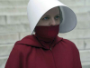 A photograph of a woman in a red cloak and a white hat