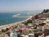 A highway stretches along the sea as Tangiers rises up on the hillside bordering