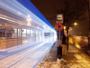 a tram in Hungary creates a streak of blue lights at night