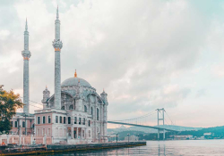 A photograph of an ornate building jutting out over a body of water