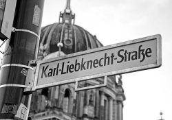 A black and white photograph of a street sign that reads Karl Liebknecht Straße