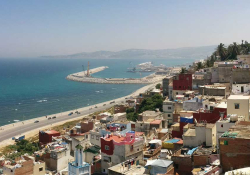 A highway stretches along the sea as Tangiers rises up on the hillside bordering