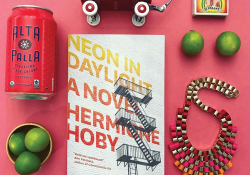 An Instagram style photo of a book surrounded by other objects on a flat pink background